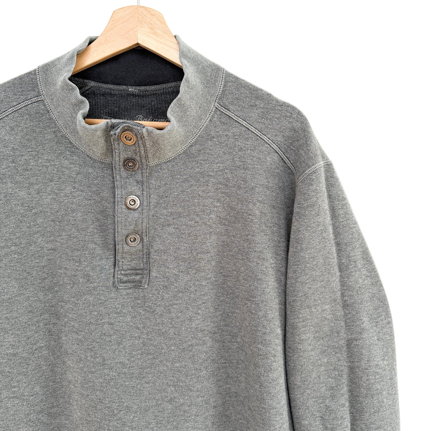 Gray henley shirt on a wooden hanger against a white background