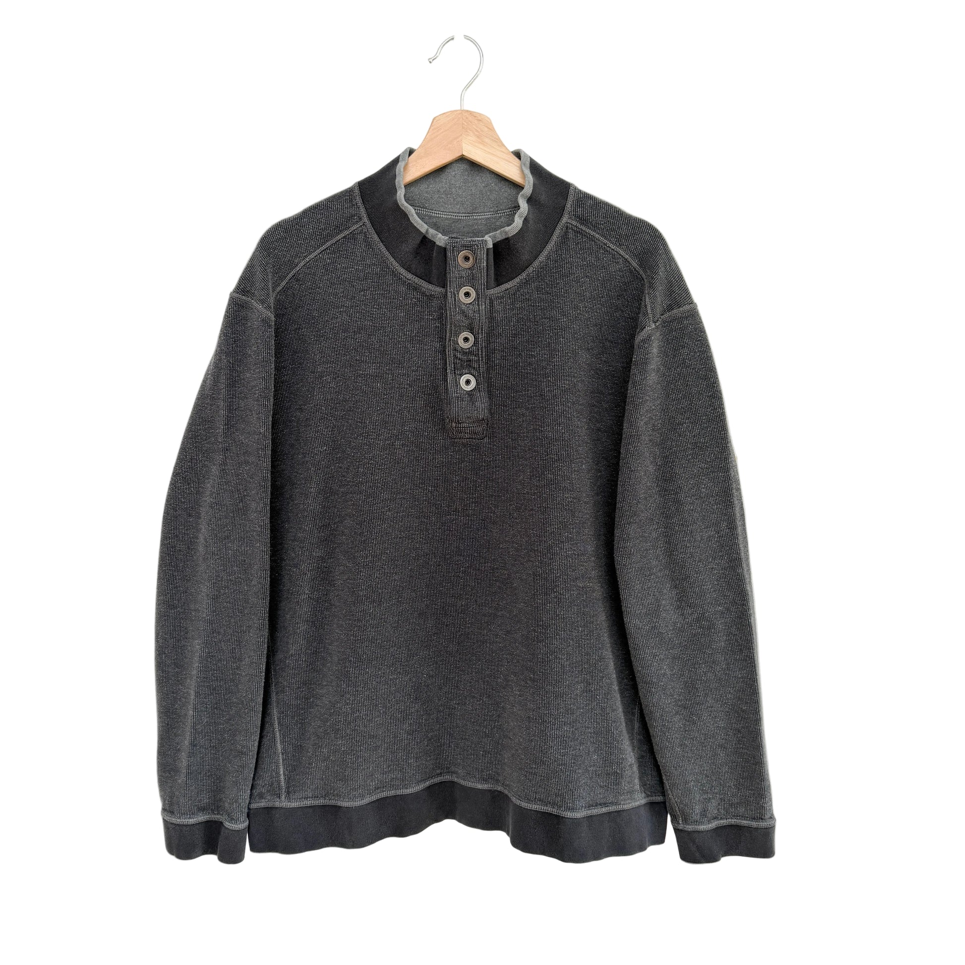 Gray pullover with button details on a hanger against a white background