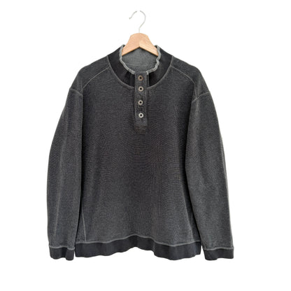 Gray pullover with button details on a hanger against a white background
