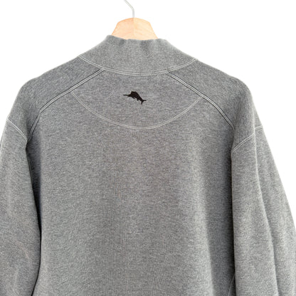 Gray pullover with a small logo on the chest area, hanging against a white background.