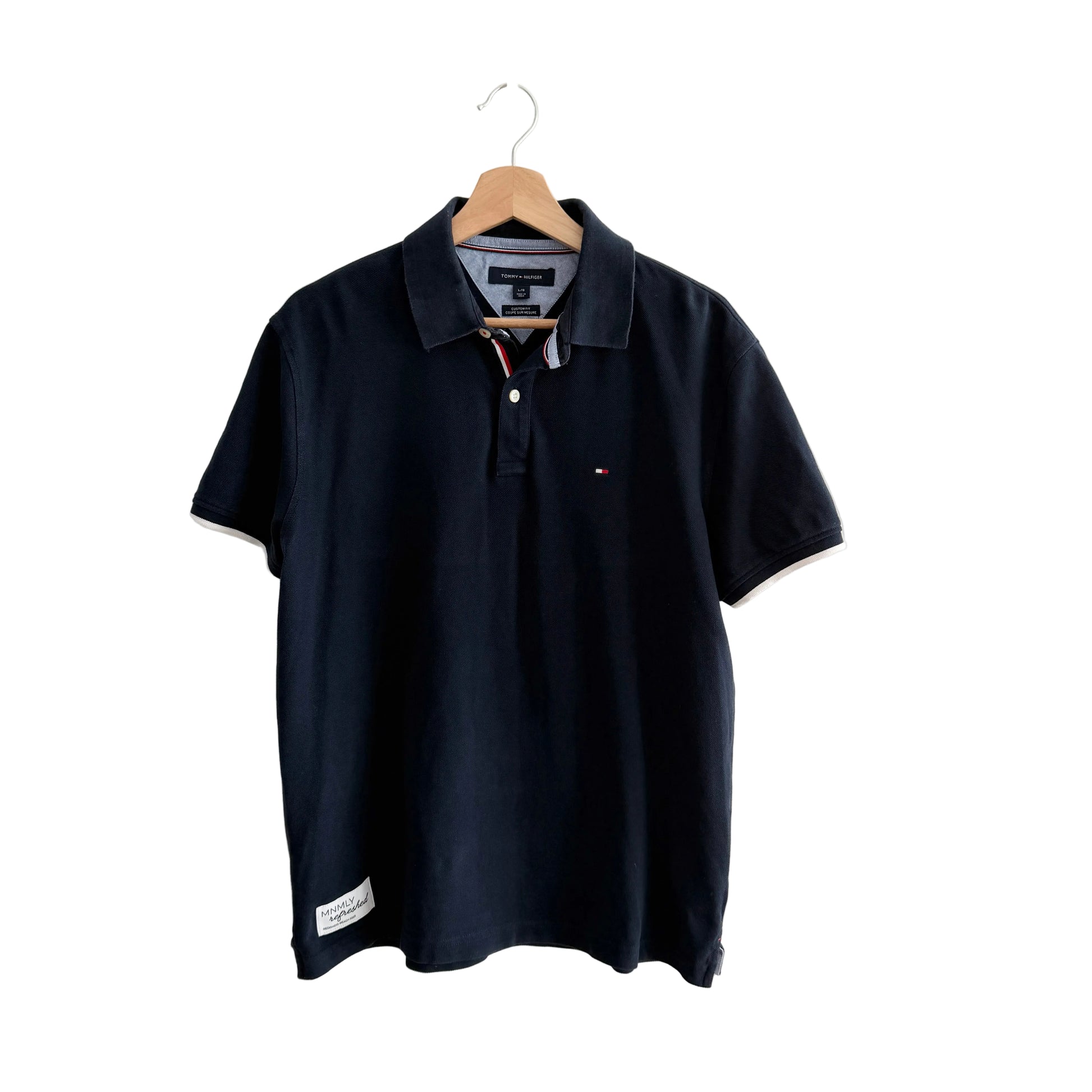 Navy blue polo shirt on a hanger against a white background