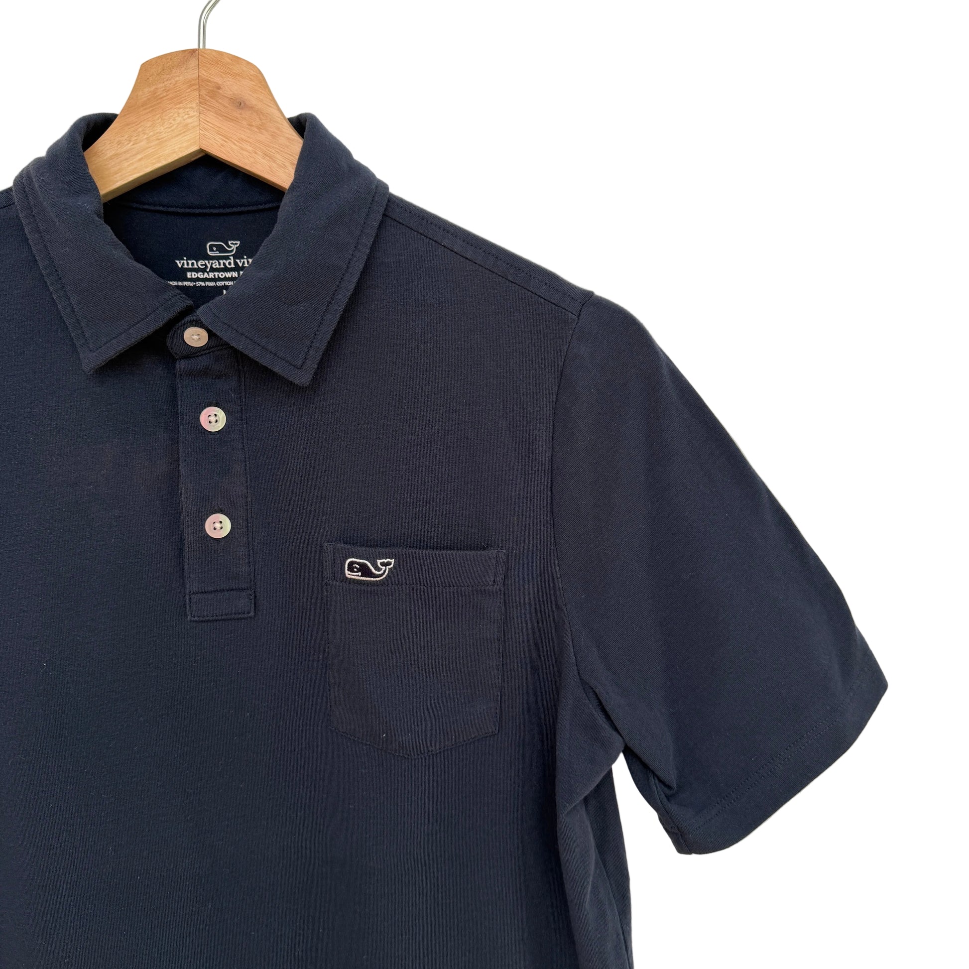 Navy blue polo shirt with a brand logo on a beige background