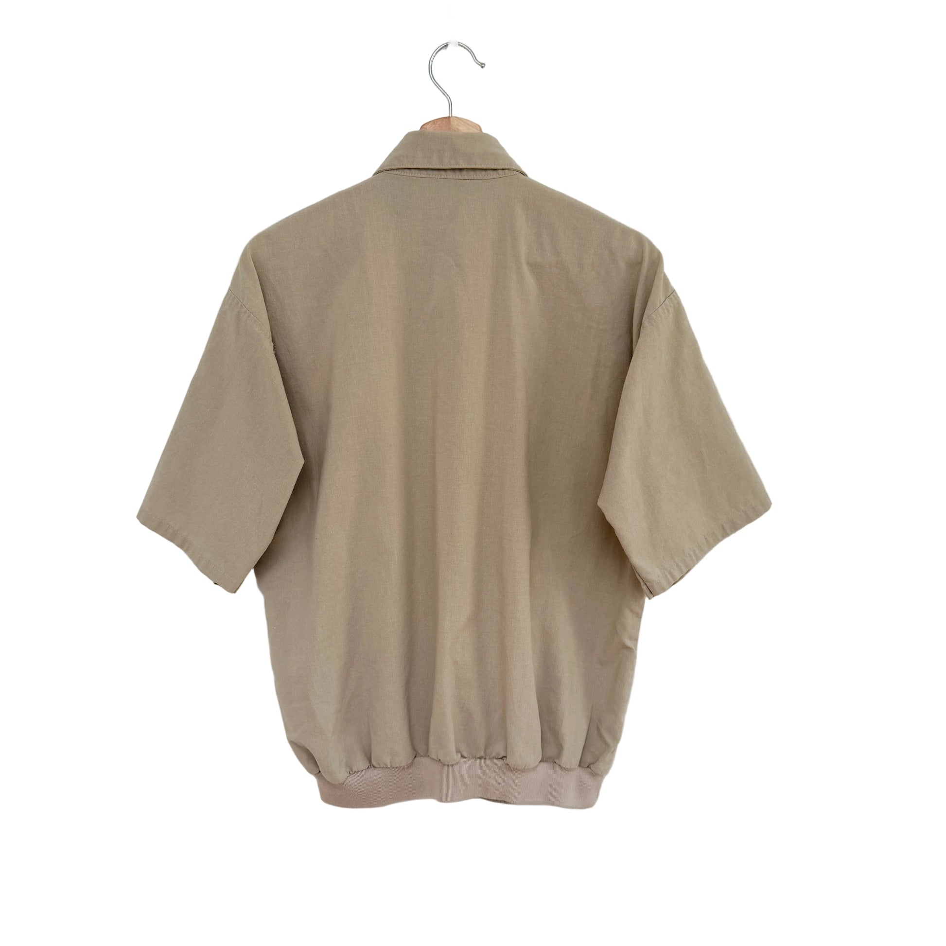 Beige shirt on a hanger against a white background