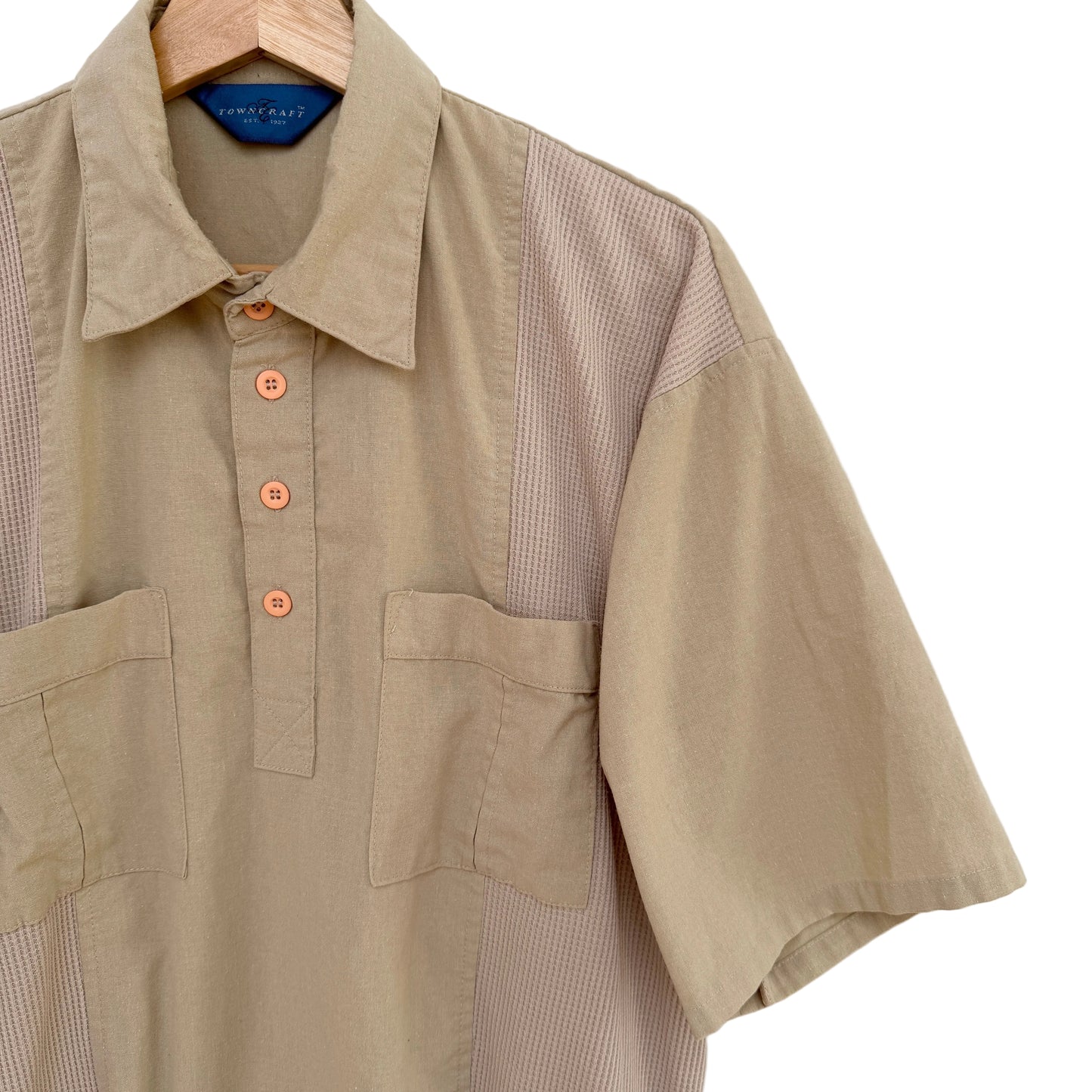 Beige shirt with button details on a white background