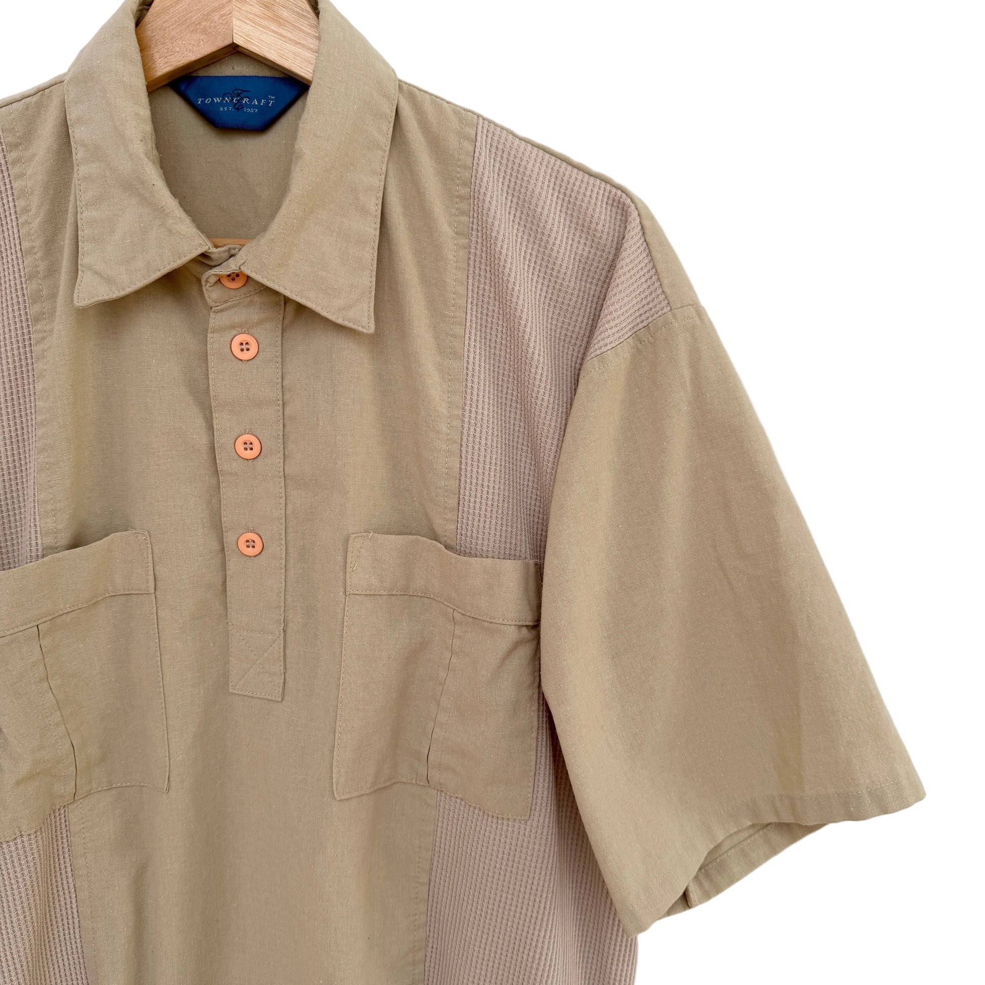 Beige shirt with button details on a white background