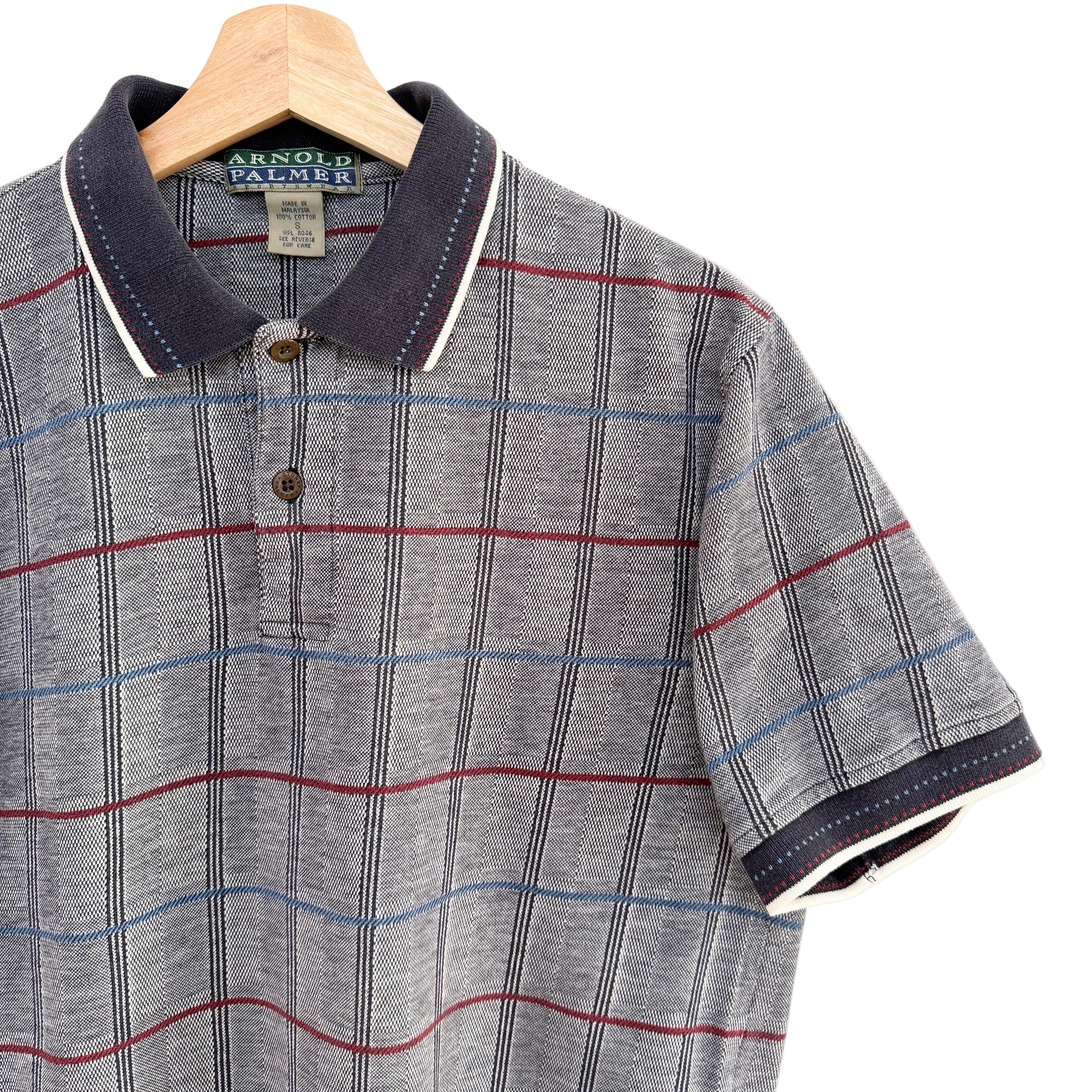 Plaid polo shirt on a hanger with a visible brand label.