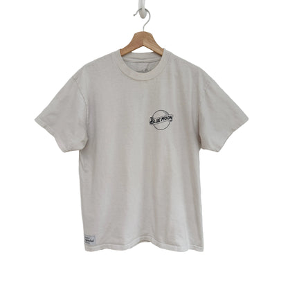 white t-shirt with a logo on a hanger against a white background