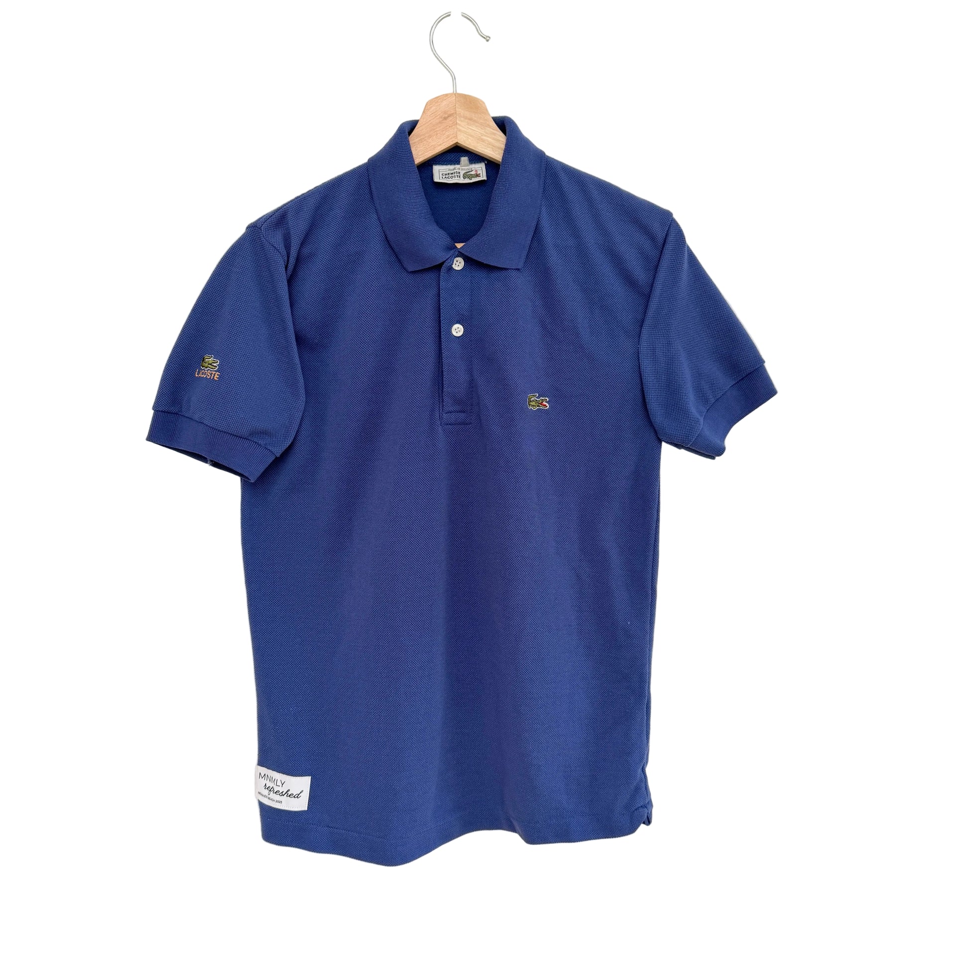 Blue polo shirt on a hanger against a white background