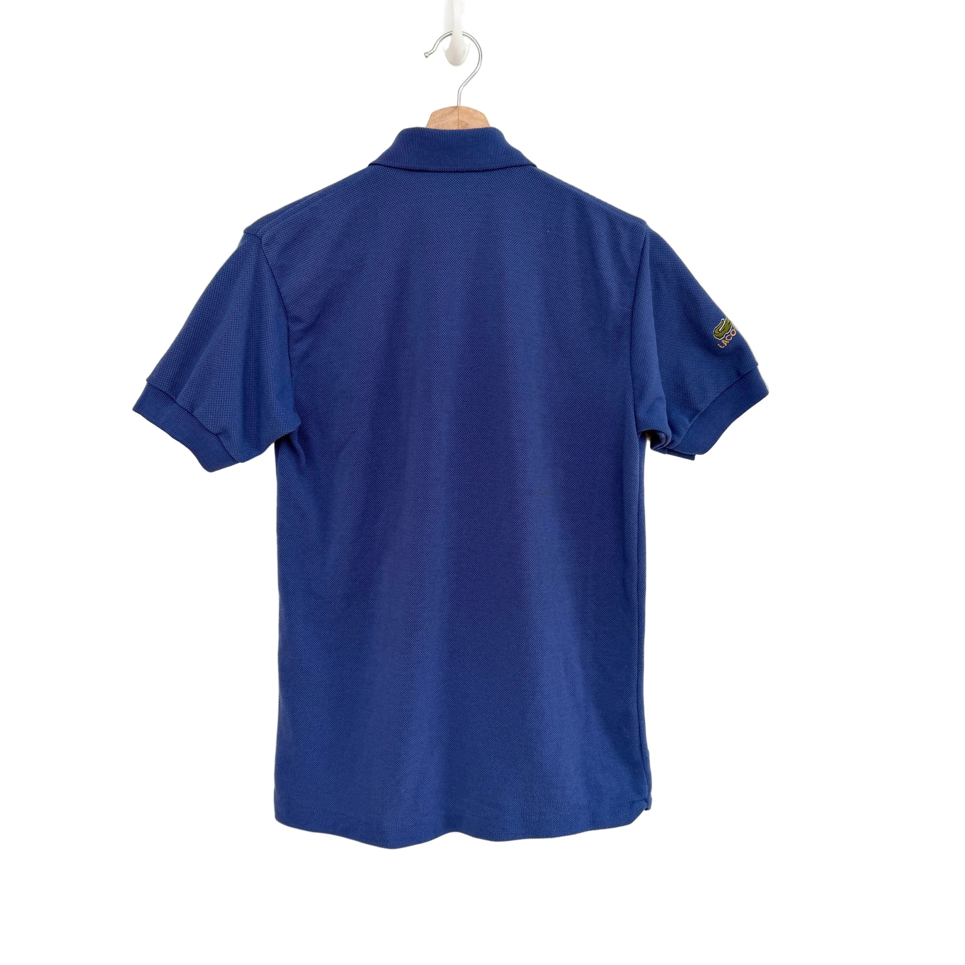 Blue polo shirt on a hanger against a white background