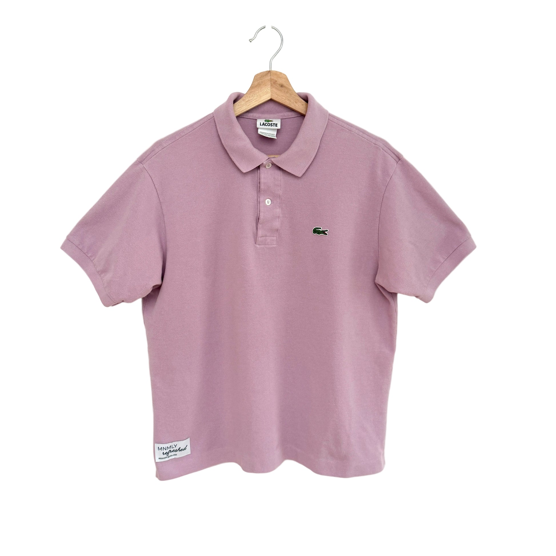 Lavender polo shirt on a hanger against a white background