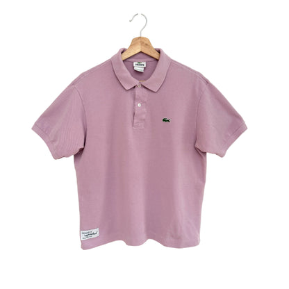 Lavender polo shirt on a hanger against a white background