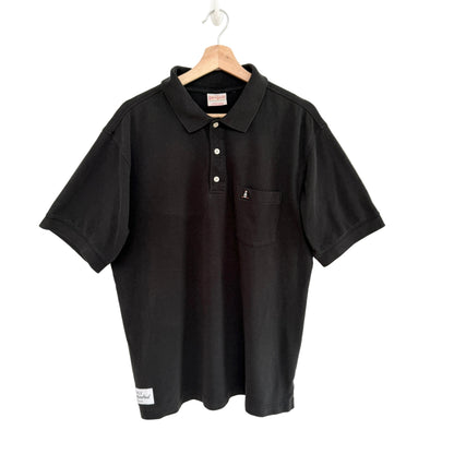Black polo shirt on a hanger against a white background