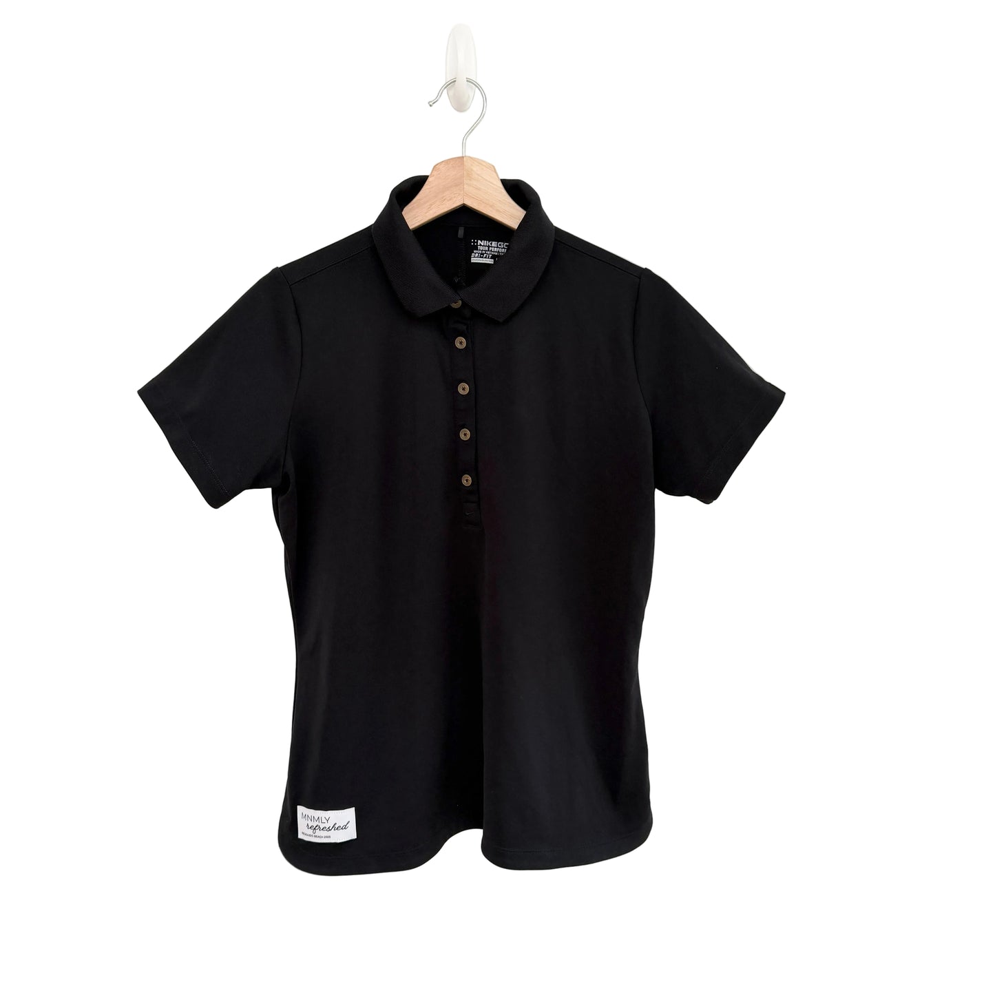 Black polo shirt on a hanger against a white background