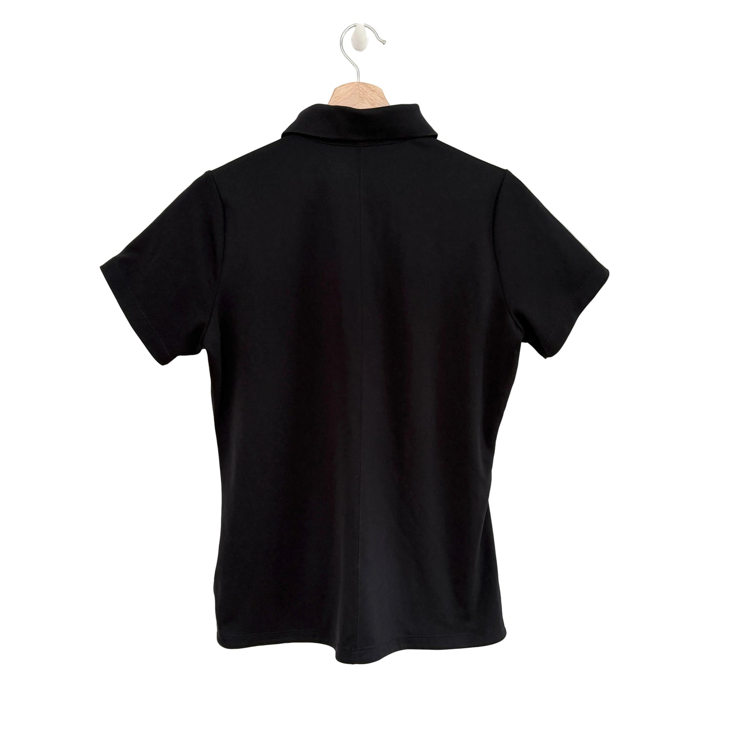 Black polo shirt on a hanger against a white background