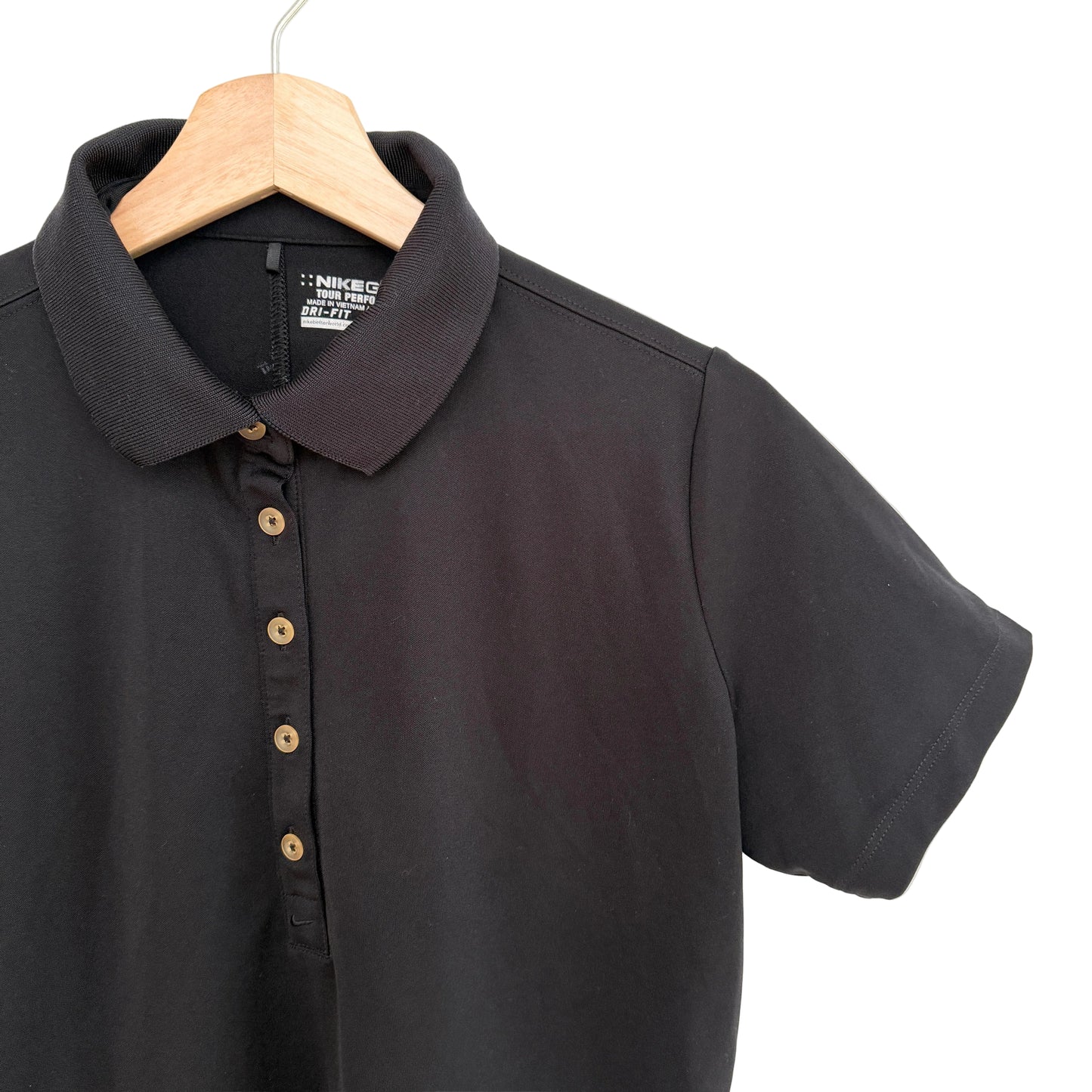 Black polo shirt on a wooden hanger against a white background