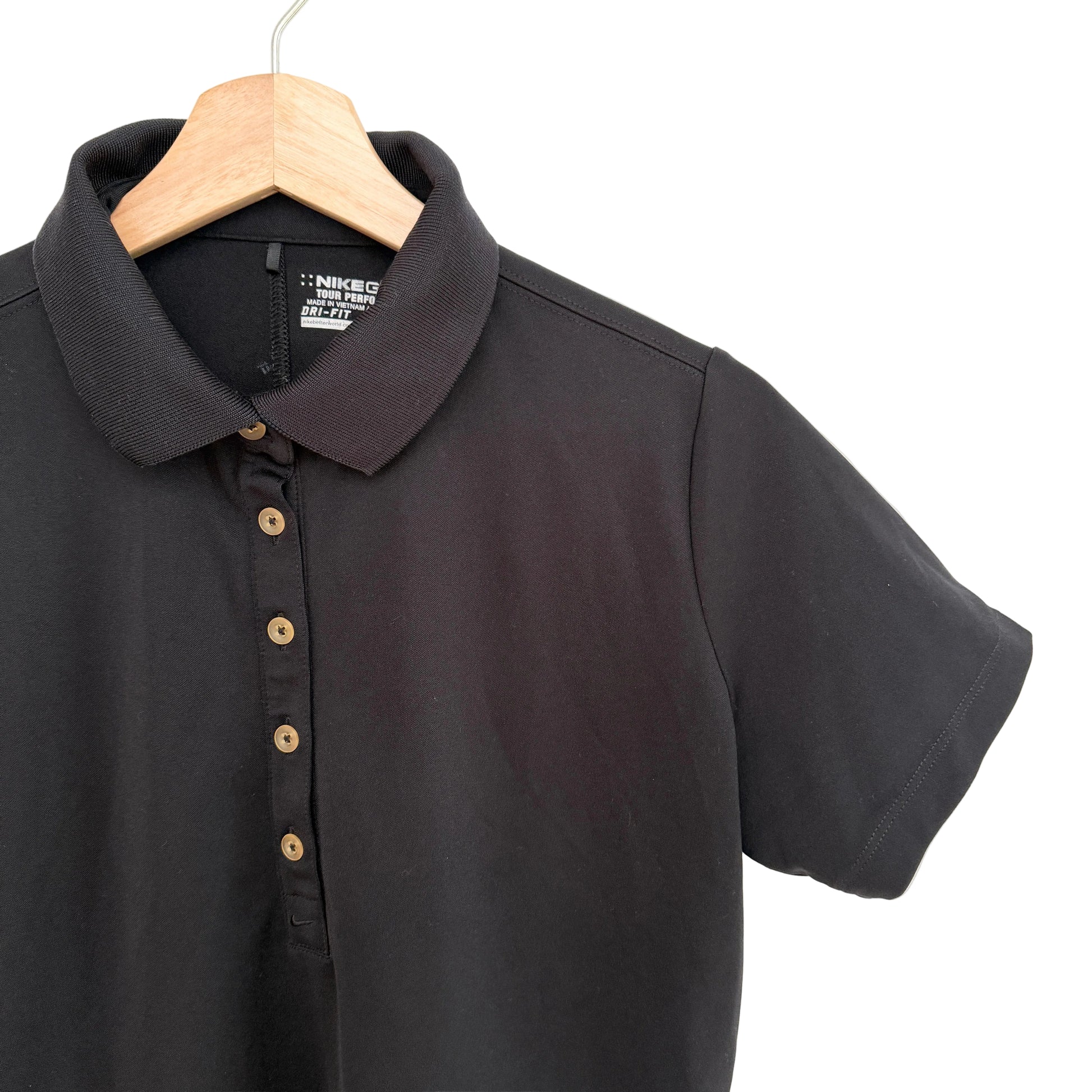 Black polo shirt on a wooden hanger against a white background
